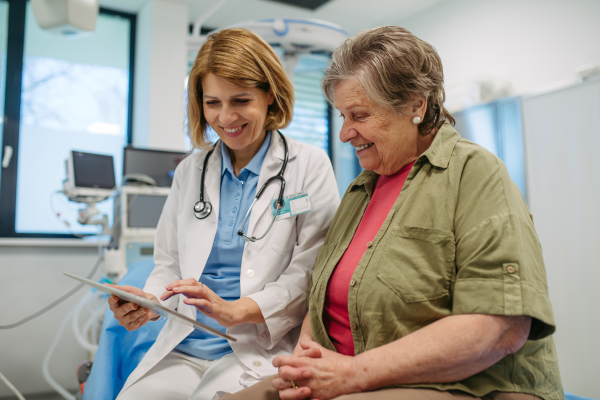 Geriatrician talking about test results with senior patient during check-up. Medical consultation.