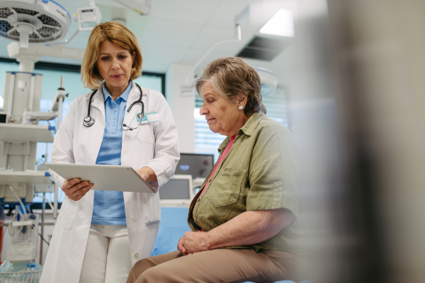 Geriatrician talking about test results with senior patient during check-up. Medical consultation.