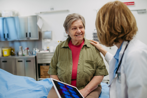 Geriatrician explaining test results to senior patient during check-up. Medical consultation.