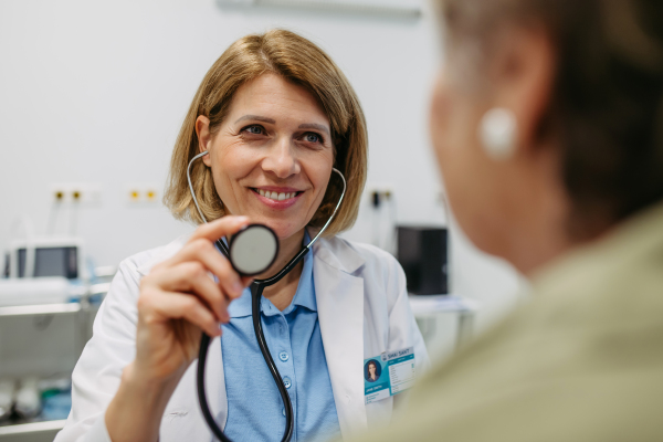 Geriatrician listening to senior patient's heartbeat. Routine health exam for elderly woman.