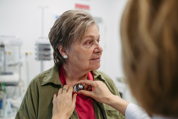 Elderly patient having heart checked by geriatric doctor. Health exam for elderly woman.