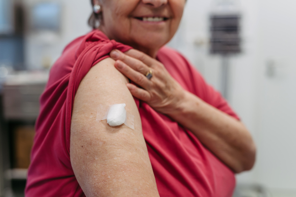 Close up of arm of elderly patient after vaccination. Preventive care.