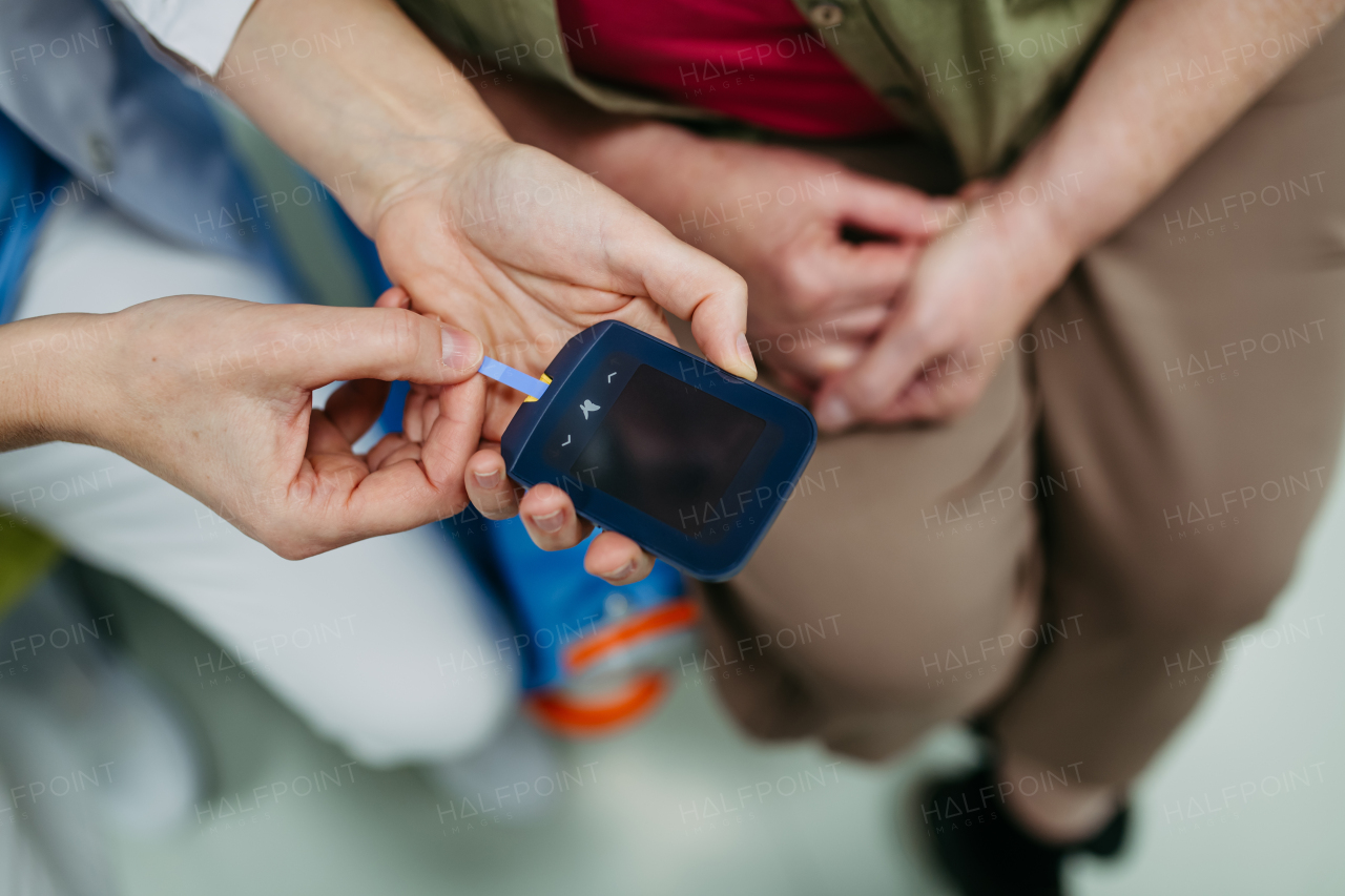 Top view of nurse preparing glucose meter for blood sugar test