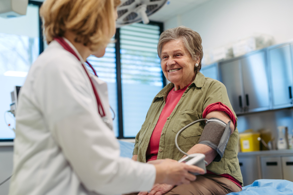 Senior woman having blood pressure checked during preventive medical exam