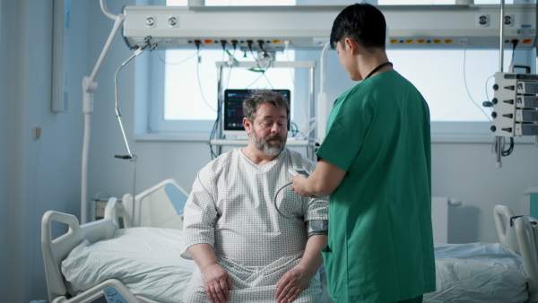 Male doctor measuring blood pressure of overweight patient.