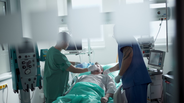 A medical team providing oxygen ventilation to unconscious patient in hospital.