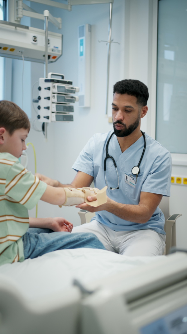 Young pediatric patient receiving orthopedic wrist brace after arm injury.