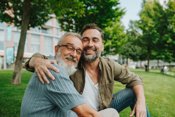 Portrait of handsome mature man and his older father hugging each other. Fathers day concept.