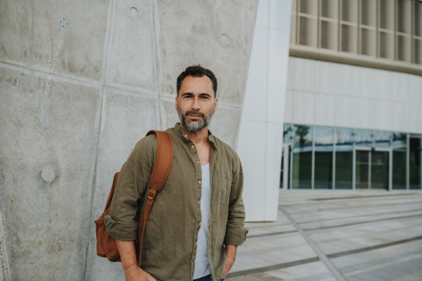 Confident middle-aged male standing casually in city setting.