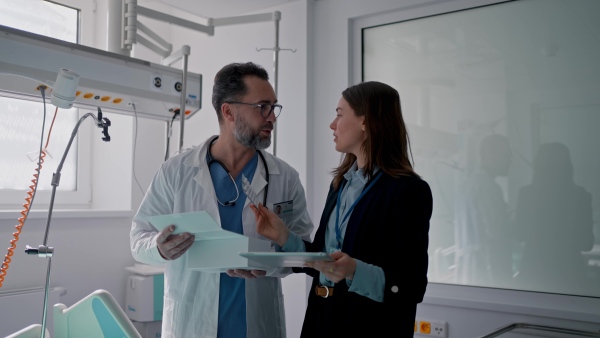 Pharmaceutical sales respresentative with doctor, hospital setting.