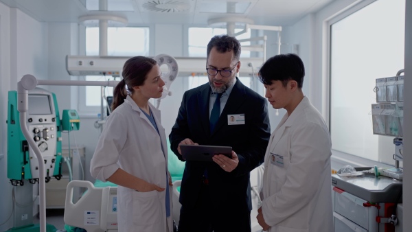 A pharmaceutical sales respresentatives showing doctor new medications. Group presentation in hospital setting.