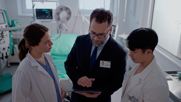 A pharmaceutical sales respresentatives showing doctor new medications. Group presentation in hospital setting.