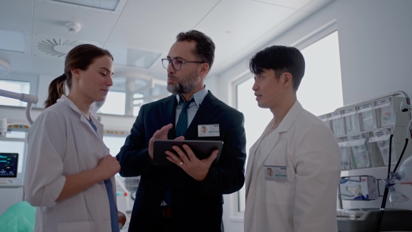 A pharmaceutical sales respresentatives showing doctor new medications. Group presentation in hospital setting.