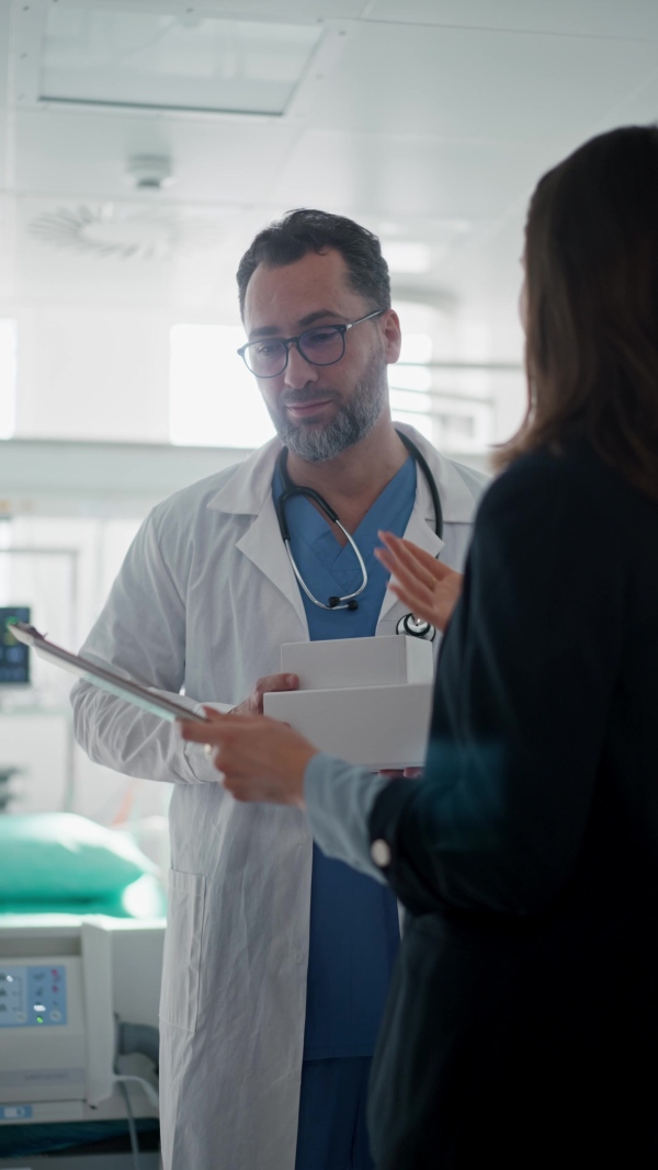 Pharmaceutical sales respresentative with doctor, hospital setting.