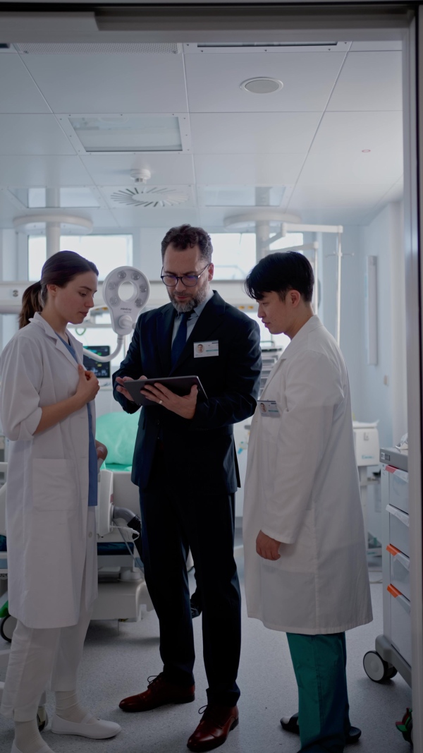 A pharmaceutical sales respresentatives showing doctor new medications. Group presentation in hospital setting.