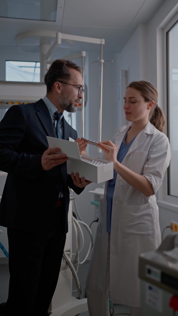 Pharmaceutical sales respresentative with doctor, hospital setting.