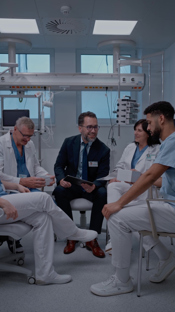 A pharmaceutical sales respresentative showing medical satff new medications. Group presentation in hospital setting.