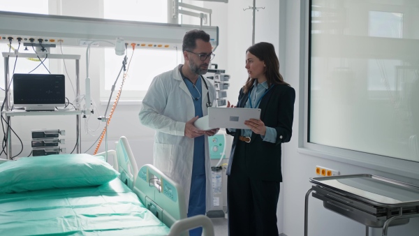 Pharmaceutical sales respresentative with doctor, hospital setting.