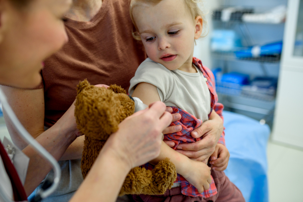 Doctor placing cotton and medical tape on the injection spot. Preventive care.