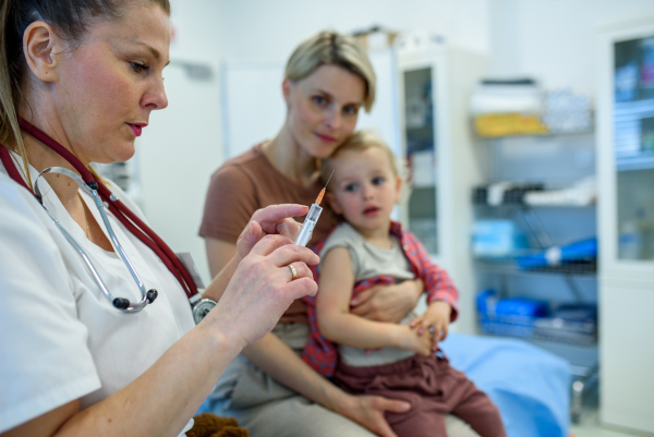 Toddler getting vaccinated during pediatric checkup. Preventive care.