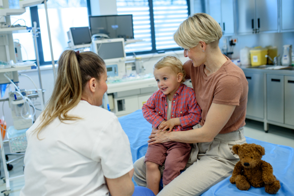Female pediatrician examing little boy during preventive health check up.