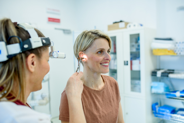 Female patient undergoing ear check-up at specialist appointment, ENT clinic.
