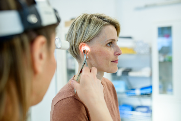 Female patient undergoing ear check-up at specialist appointment, ENT clinic.