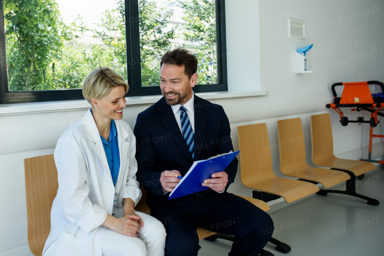 Doctor and pharmaceutical representative talking about new drug in clinical setting.