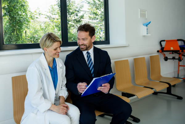 Doctor and pharmaceutical representative talking about new drug in clinical setting.
