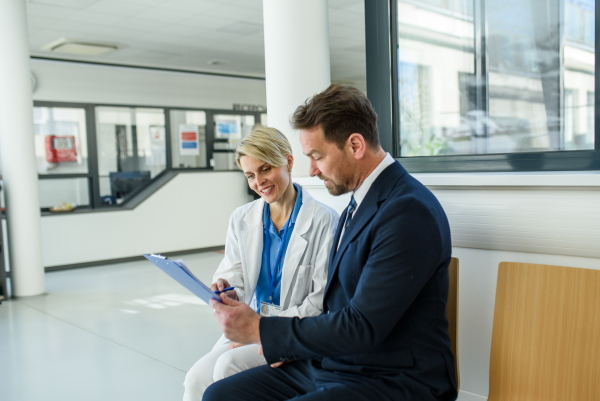 Doctor and pharmaceutical representative talking about new drug in clinical setting.