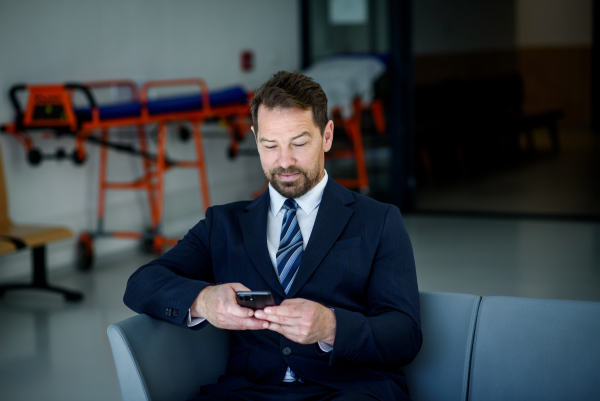 Business professional with smartphone in hand, reading email, sales representative.