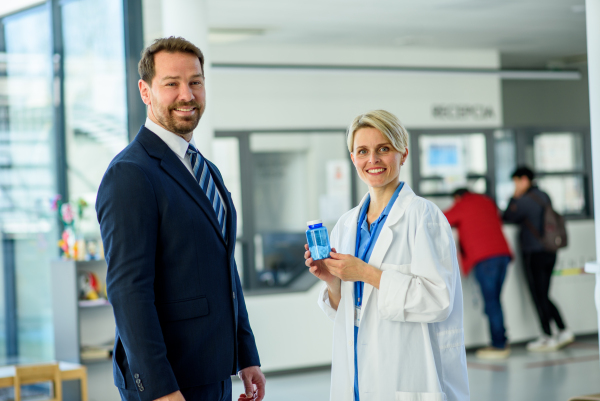 Doctor and pharmaceutical representative talking about new drug in clinical setting.