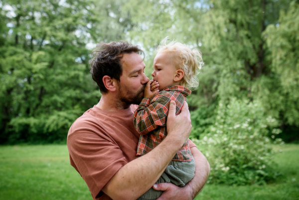 Loving father helping to injured crying toddler boy. Fatherhood concept.