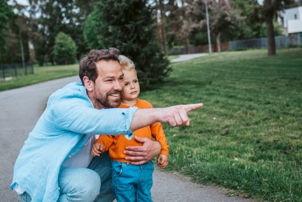Dad showing his toddler son something in the distance. Fathers day concept.