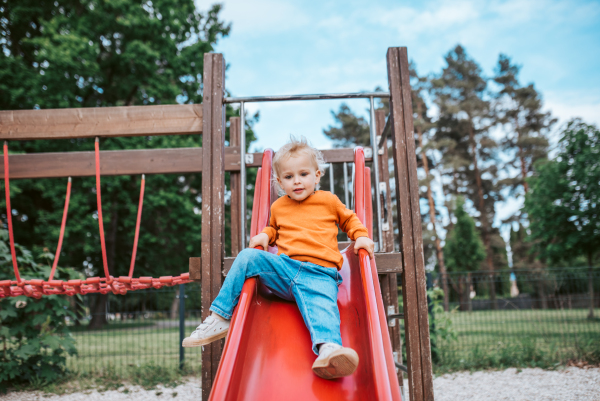 Little boy getting ready to slide. Boy having fun on playground.