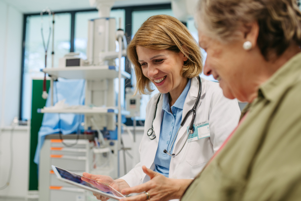 Geriatrician talking about test results with senior patient during check-up. Medical consultation.