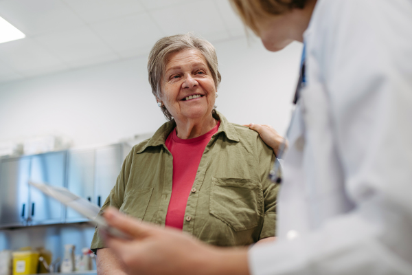 Geriatrician talking about test results with senior patient during check-up. Medical consultation.