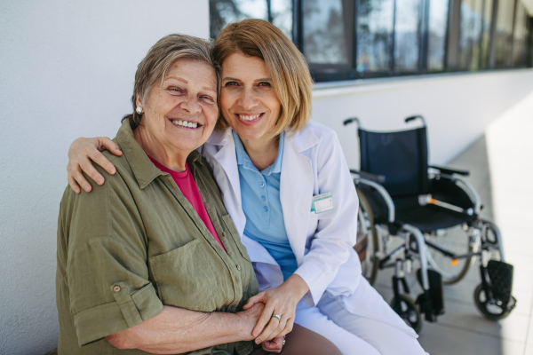 Female doctor spending time with resident of nursing home. Senior health care.
