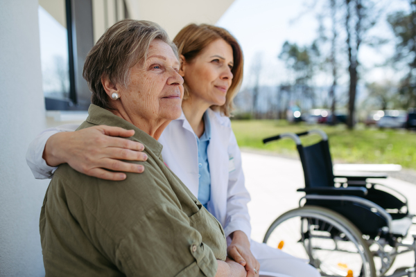 Female doctor spending time with resident of nursing home. Senior health care.