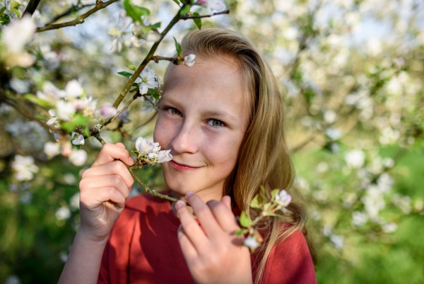 Girl enjoying spring blossoms in the garden.